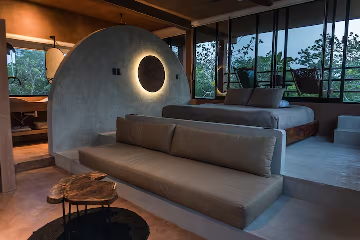 Revivis Suite — moody bedroom with backlit circular wall feature