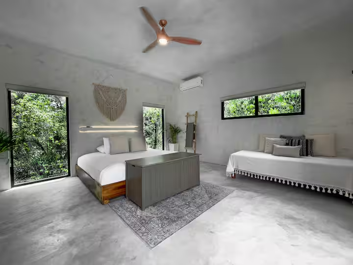 Okain Suite — wide view with ceiling fan, single daybed, and floor-to-ceiling windows