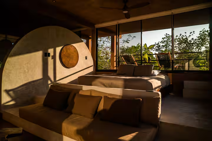 Revivis Suite — golden hour light across the king bed