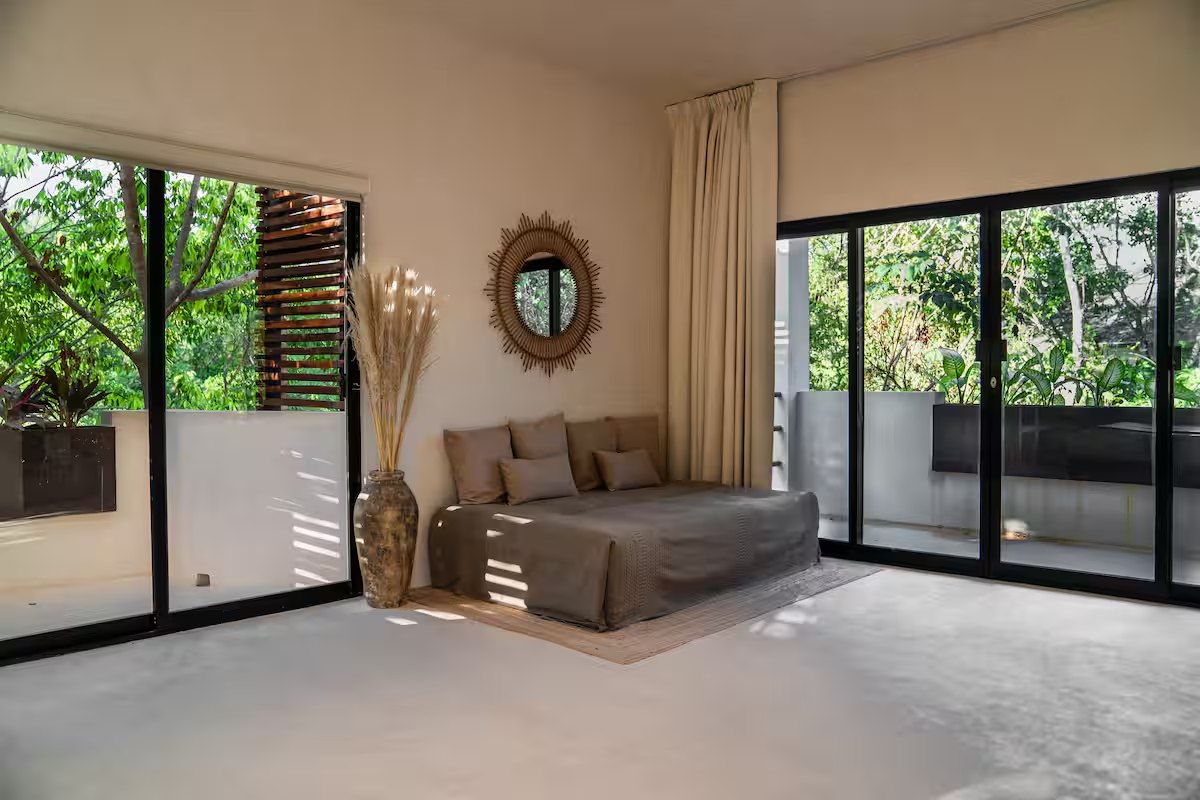 Cajmere Suite — sofa bed corner framed by lush balcony views
