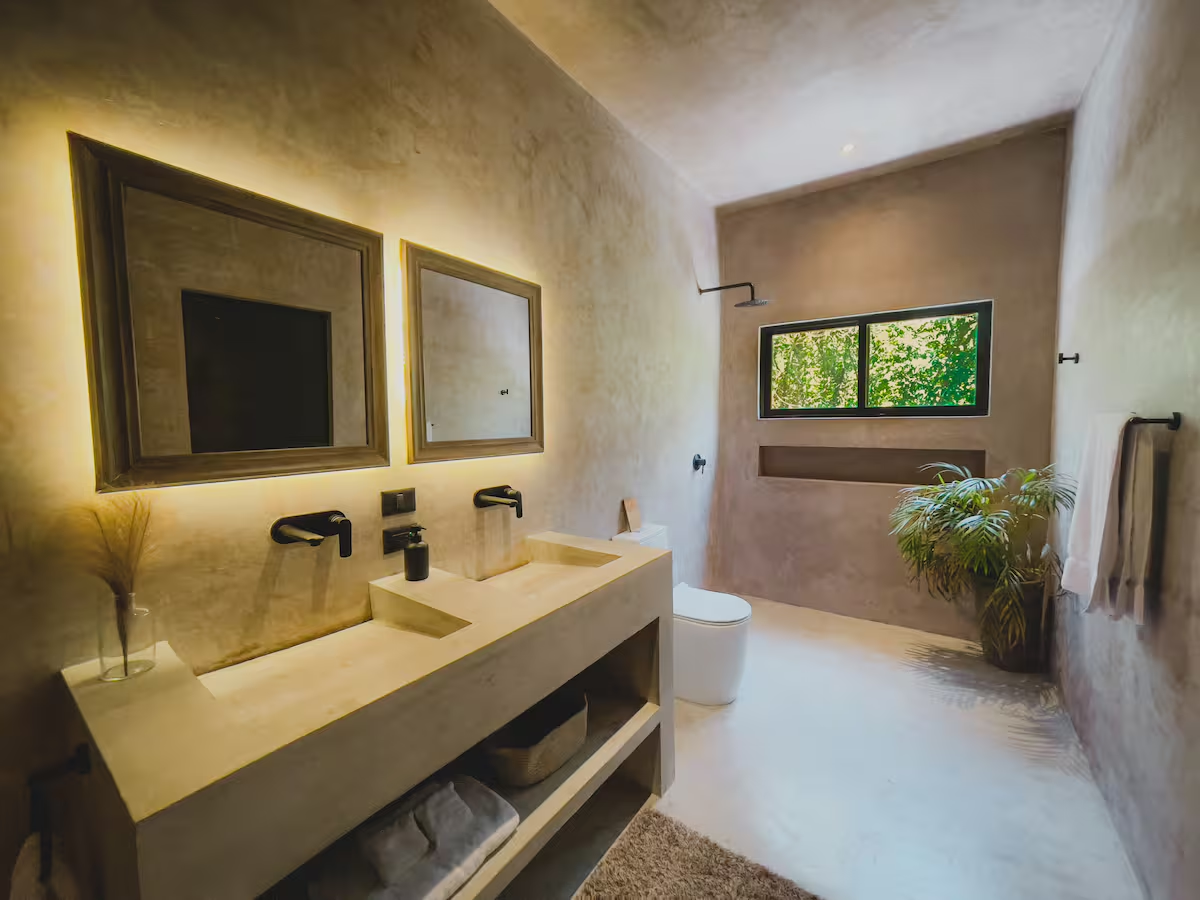 Okain Suite — double-sink concrete vanity with rainshower and garden window