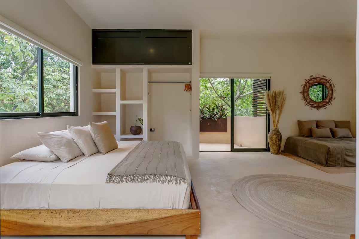 Cajmere Suite — airy bedroom with king bed and sofa bed alcove