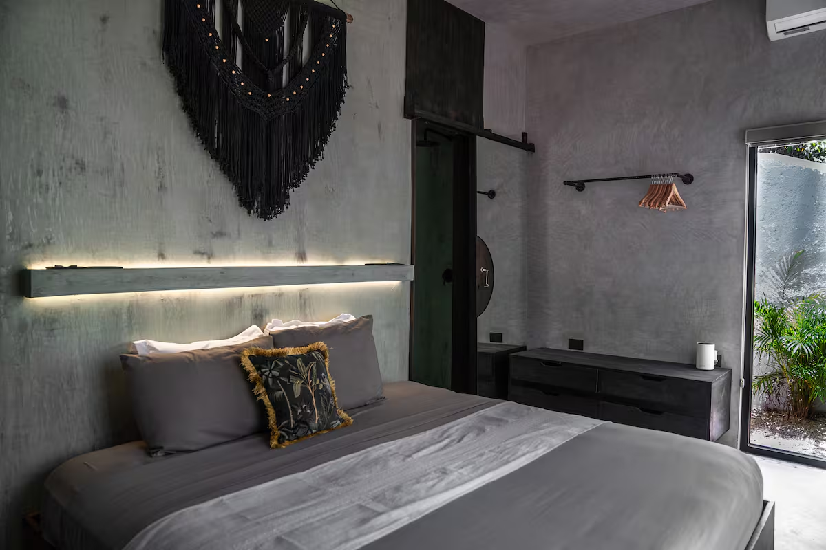 Ferro Suite — king bed with macramé wall hanging, dresser, and garden-view window