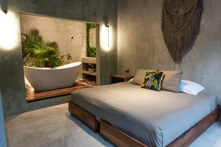 Tirzah Suite — bedroom with sconce-lit soaking tub nook